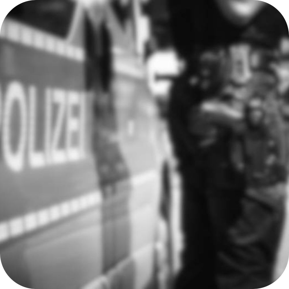 Bildausschnitt eines Polizist vor einem Polizeiwagen